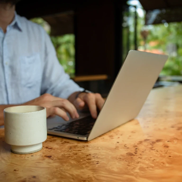 Man Working on Laptop with Coffee Outdoors